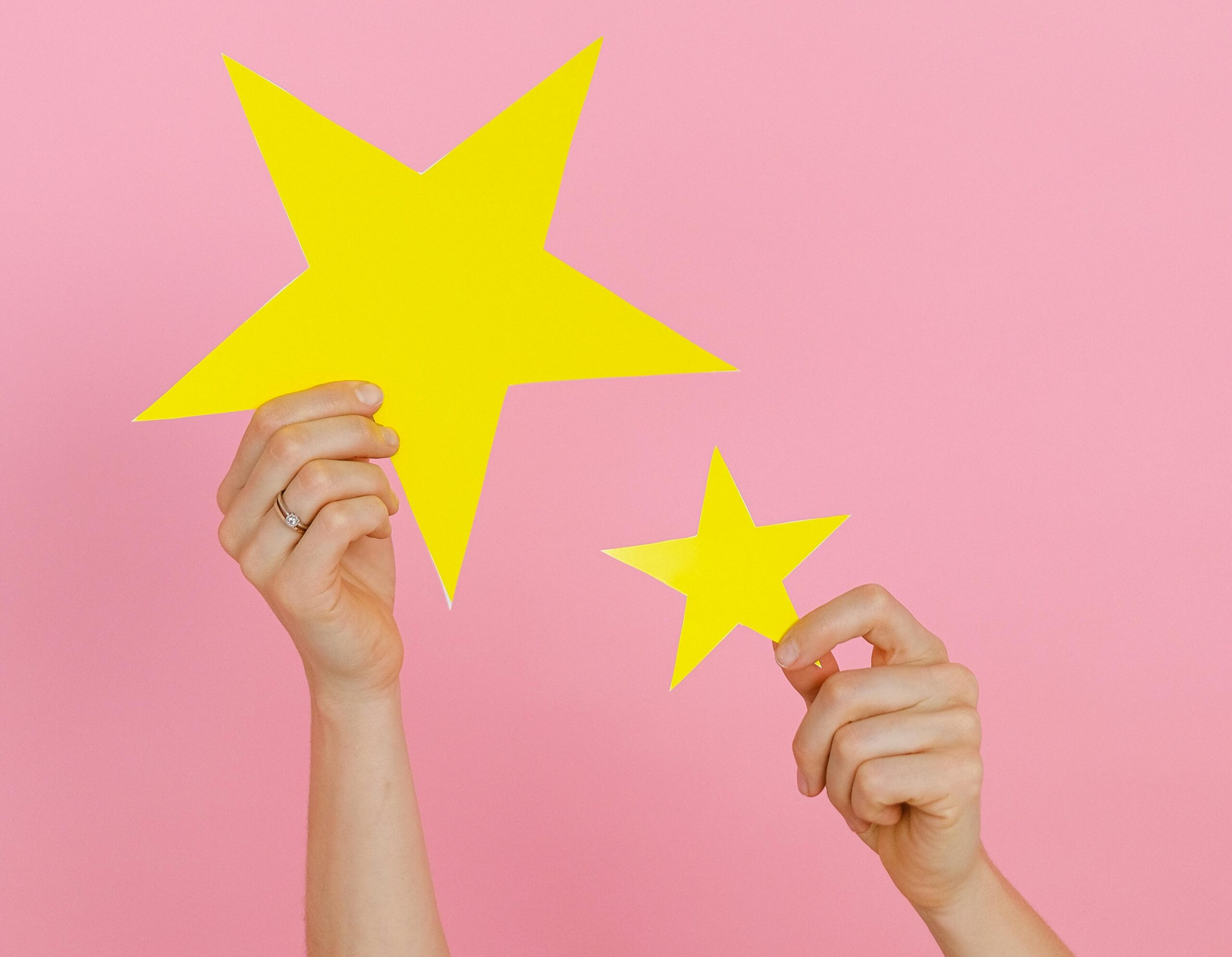 Hands holding yellow stars, symbolizing performance assessment