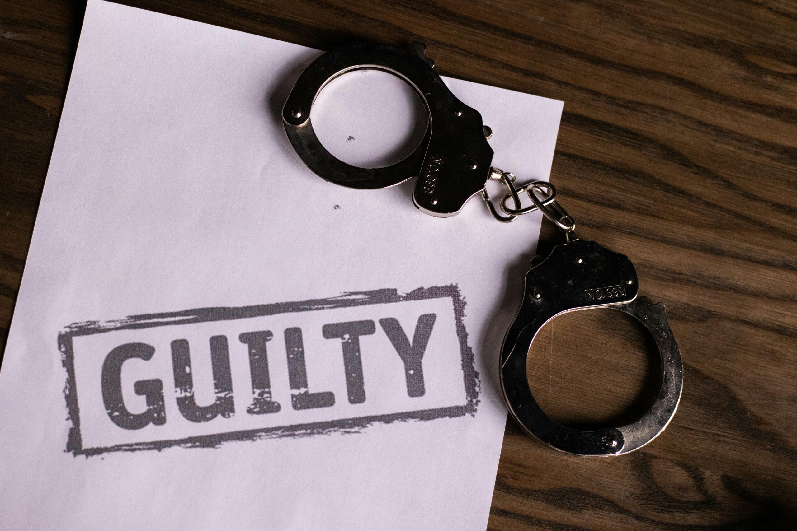 Handcuffs on a paper stamped GUILTY, relevant to criminal history employment checks.