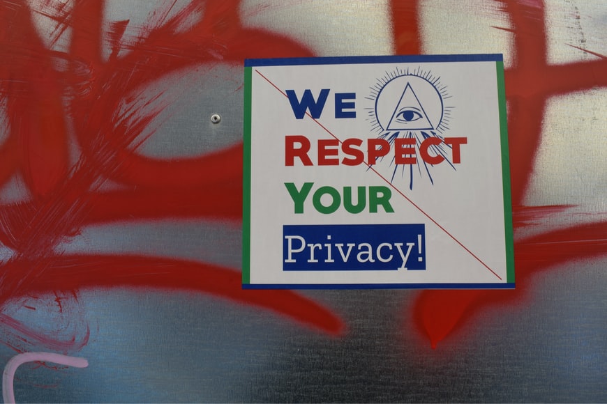 Image with red graffiti with sign in front saying we respect your privacy