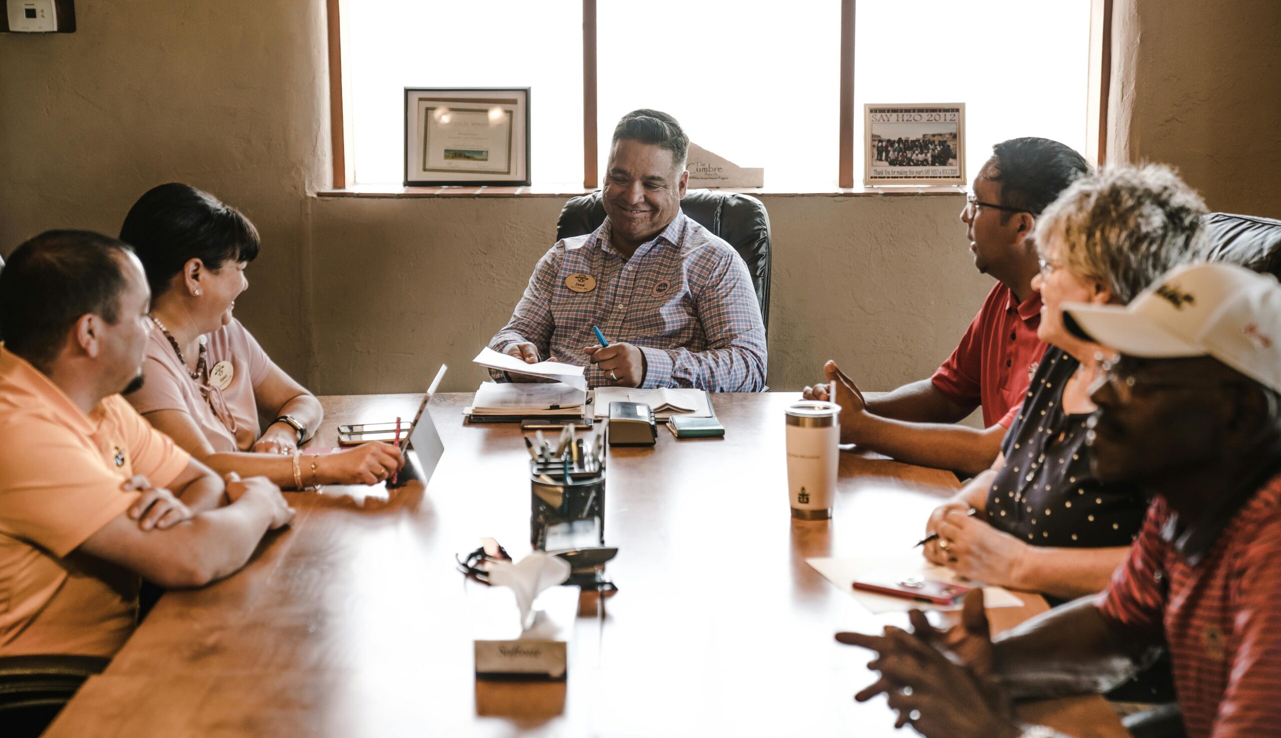 Diverse group discussing good governance policies at a conference table.