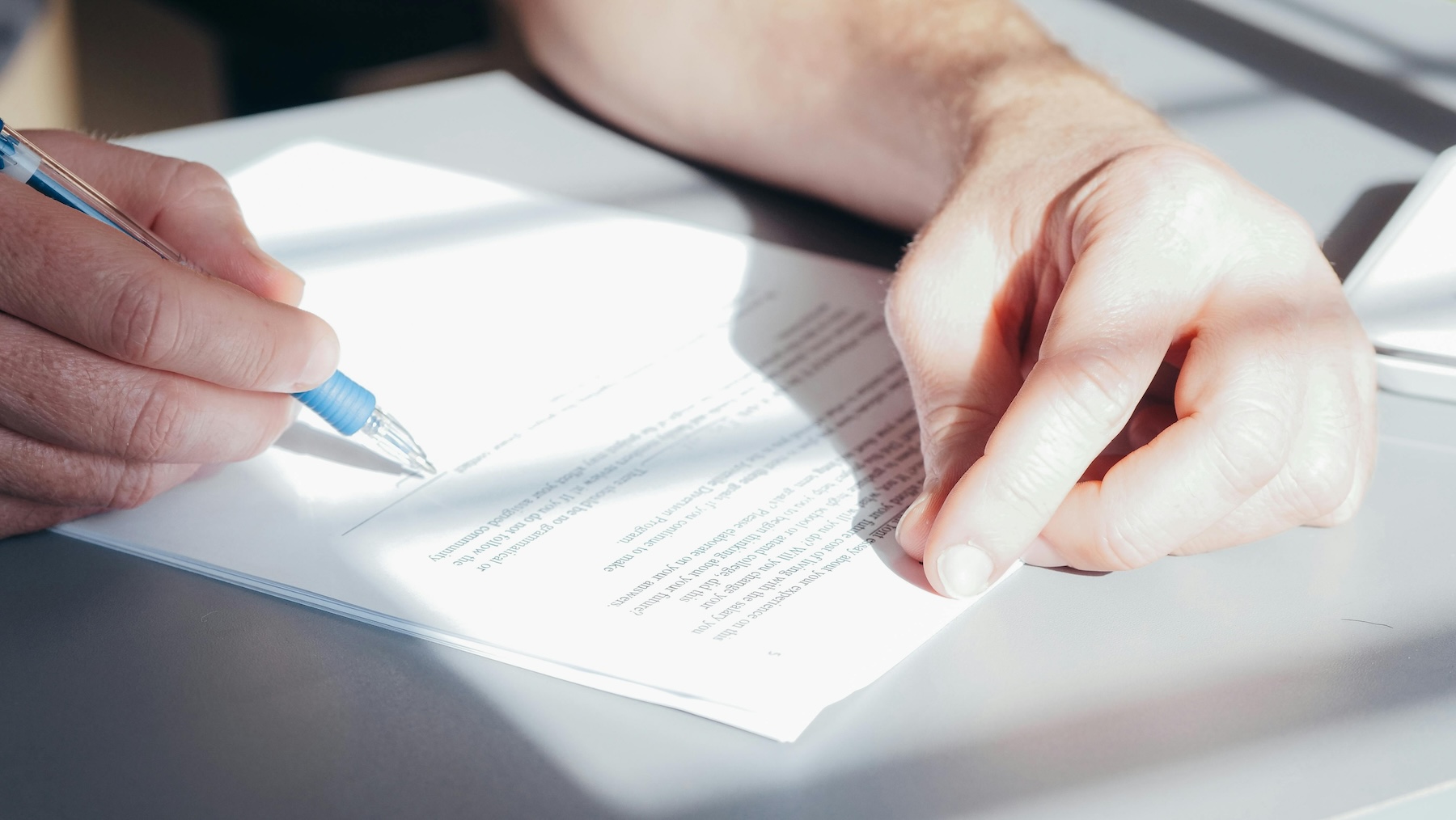 close up of someone signing a contract