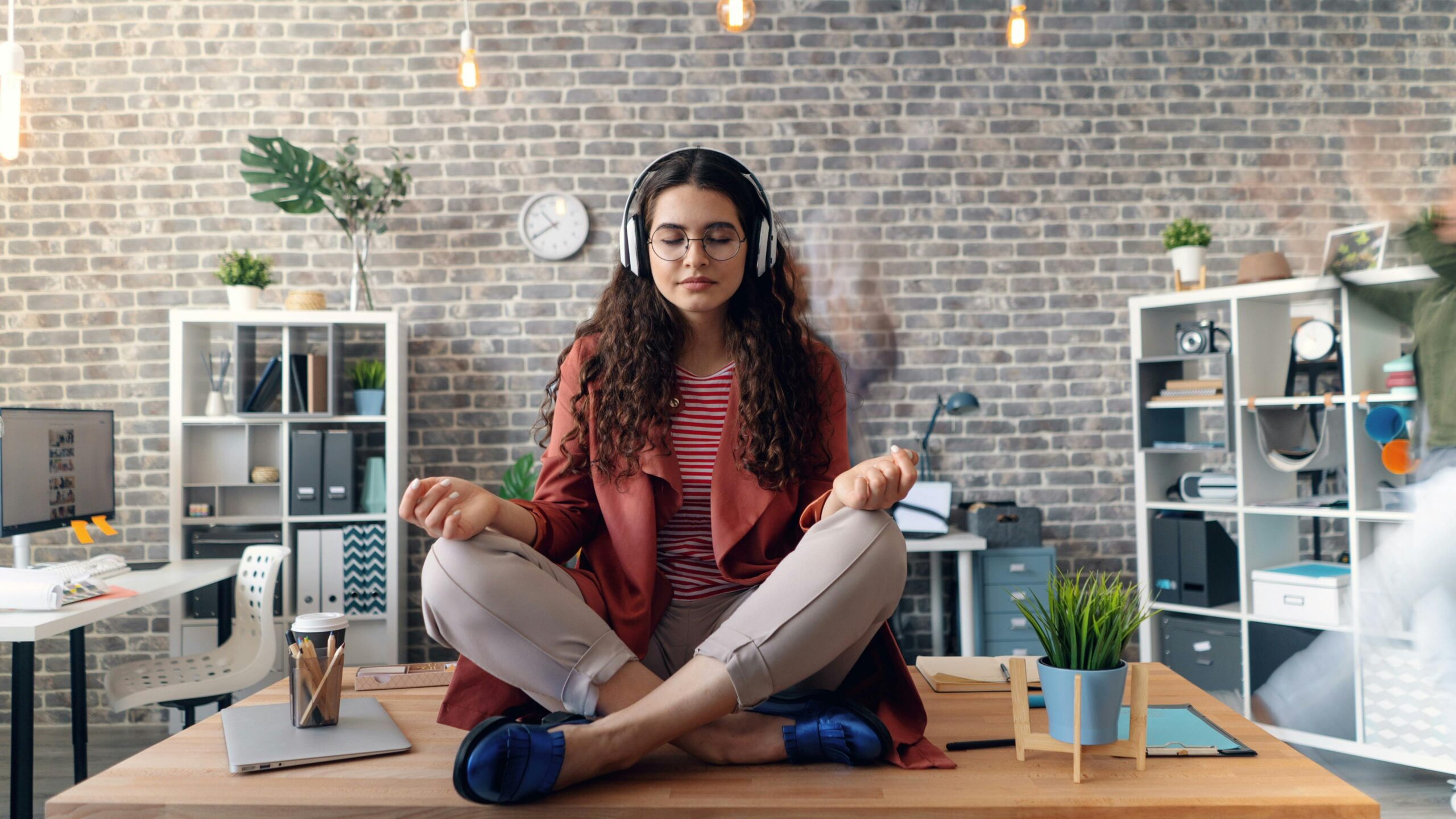 Woman meditating in office, promoting organisational justice and well-being.
