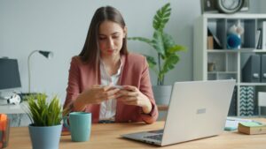 Woman reviewing mobile device policies for social services in 2026 at her desk