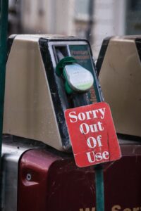 Red sign on fuel dispenser reads "Sorry Out Of Use" to inform users