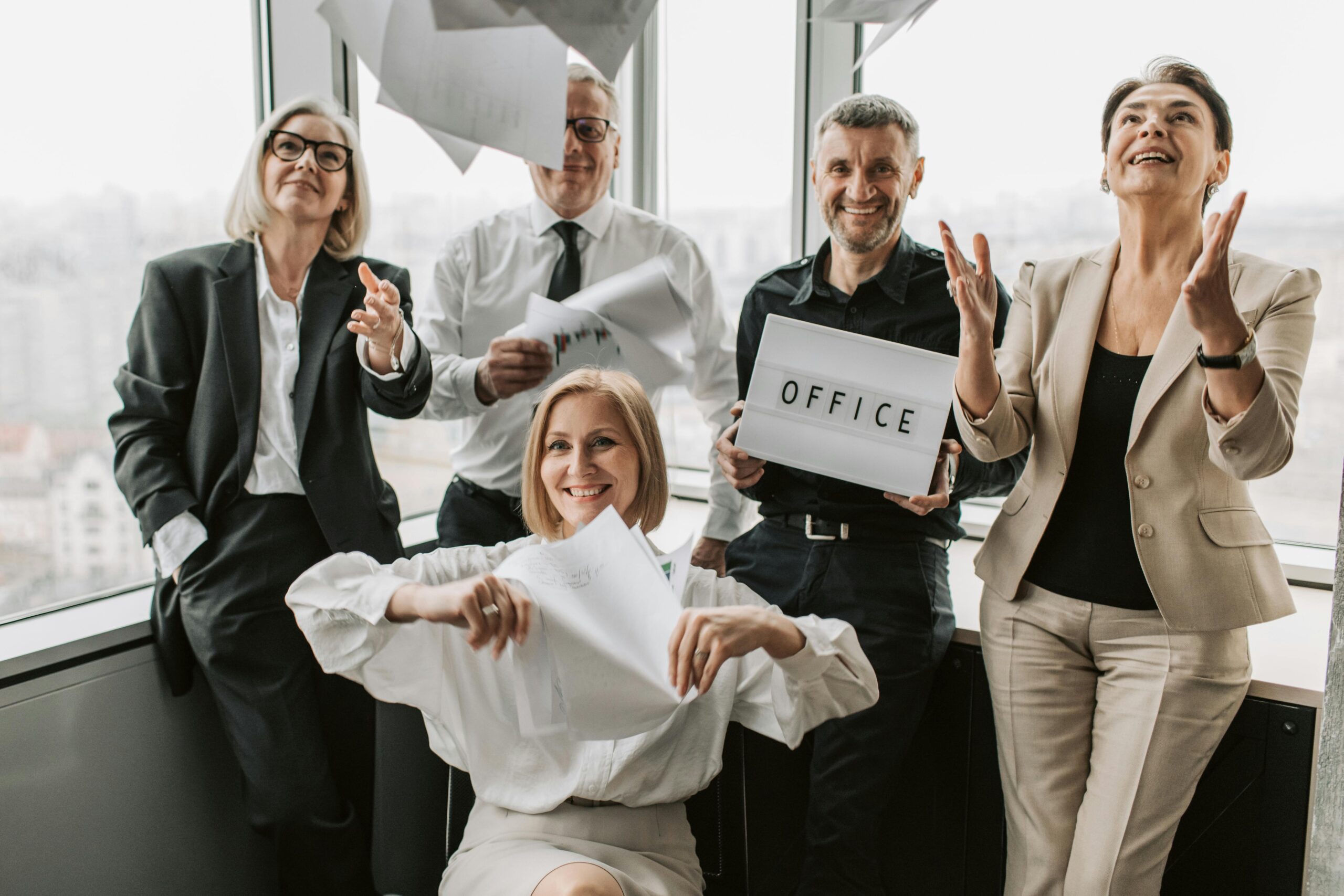Business team celebrates in office, reducing policy risk and audit stress.