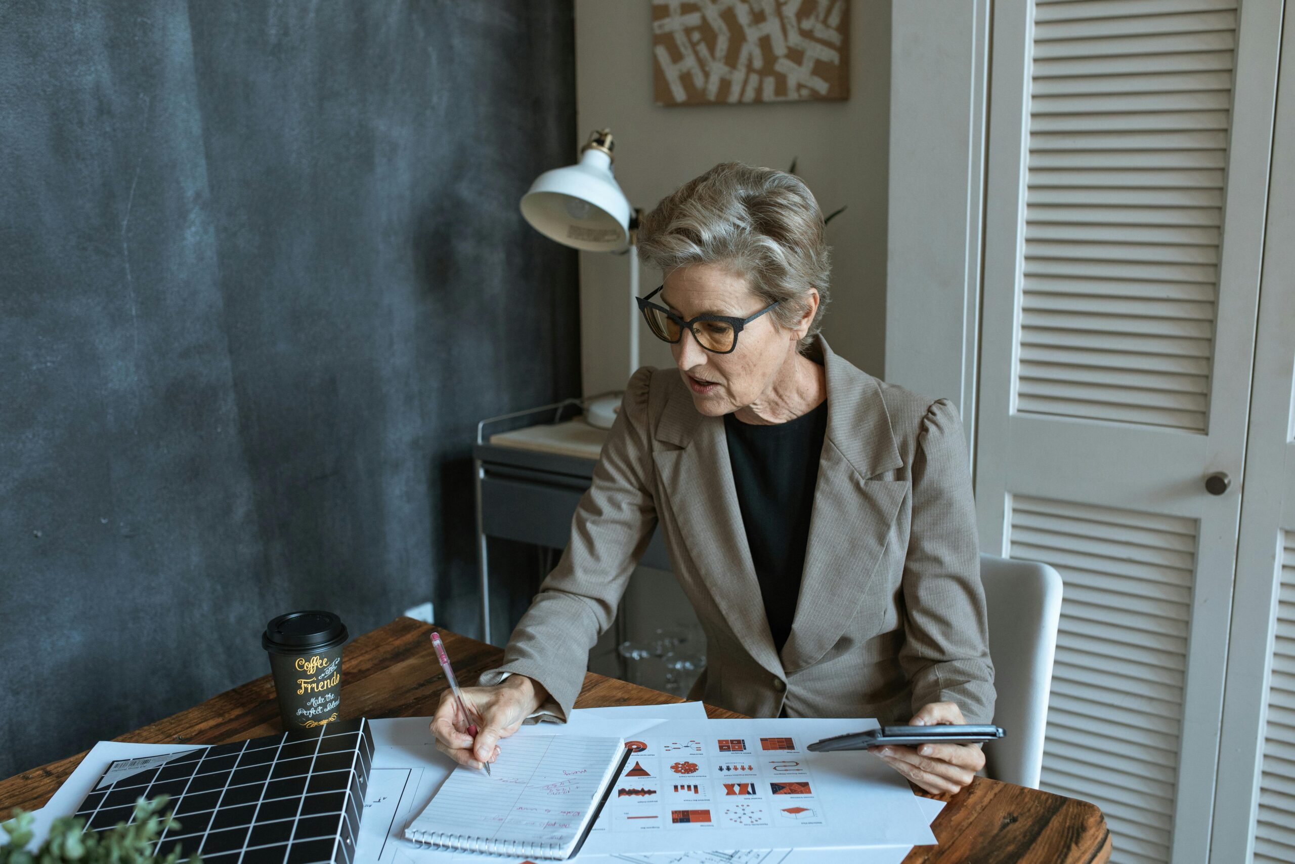 Woman in blazer reviewing documents, policy management in community services