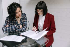 Two people reviewing policy documents for NZ social services.