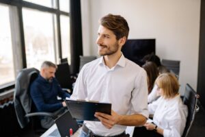 Business professional reviews policy governance documents in NZ social services office